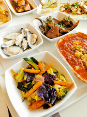 Fresh variation of nutritious seafood meze on plate and boiled vegetables. Healthy eating cuisine