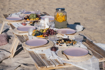 Romantic luxury picnic on the beach. Boho decoration with lemons. Bachleorette party, couple date,...