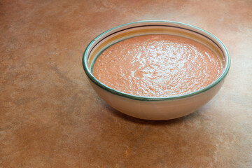 A large painted clay bowl with freshly made gazpacho. Summer and vegetable fresh food.