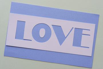 paper stencil with the word love on lavender and gray paper