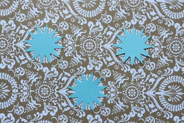 three paper star shapes on decorative paper pattern