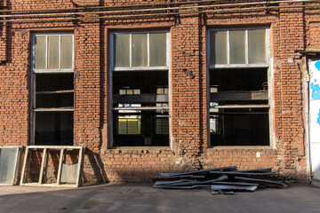 Restoration of an old red brick factory building. Replacing windows in a vintage brick building.