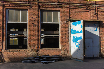 Restoration of an old red brick factory building. Replacing windows in a vintage brick building.