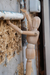 Wooden mannequin close-up climbing on pipe in the construction, vertical photo 