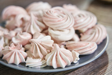 beautiful pink meringues on a plate close-up.