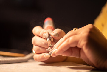 Close up of a person hands holding a manicure tool, making nails