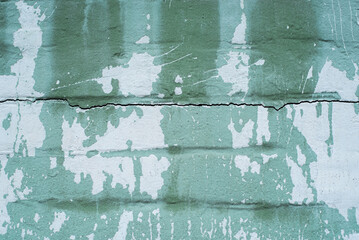Green background of  peeling paint on a brick wall