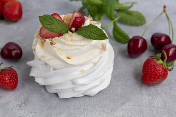 Pavlova meringue cakes with whipped cream and fresh strawberries, mint leaves. Selective focus.