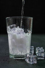 Bevanda versata nel bicchiere con il ghiaccio