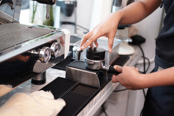 Closed up Asian Young barista woman is wearing apron and brewing coffee with machine for customers order in cafe and coffee shop. Start up small cafe business and technology Concept.