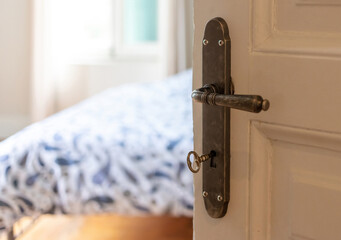 Classy hotel room or house bedroom interior. Door open, retro door knob on vintage door, close up.