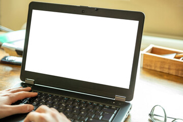 Computer screen mockup. Laptop with white blank screen on a wood desk, office background, copy space