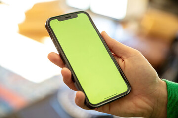 Hand hold mobile phone with blank screen. Smartphone empty display on a male hand, close up