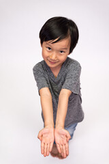 Boy wearing jeans and a gray tee in various poses, such as standing or sitting on a chair