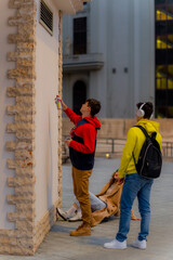 Fototapeta premium Preparing to spray paint the wall together while enjoying their time
