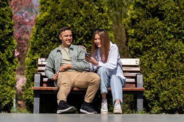 Two happy friends sharing social media in a smart phone outdoors in a park