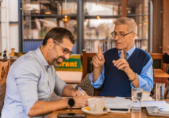 Smiling and discussing their ideas on the meeting while sitting in the cafe