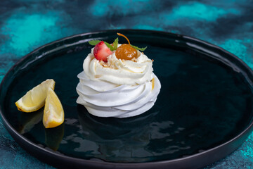 Pavlova meringue cakes with whipped cream and fresh strawberries, mint leaves. Selective focus.