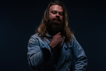 Close up portrait of handsome manly guy with beard posing in studio on a isolated background.