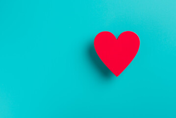 a red heart made of wooden planks placed on a blue background,
