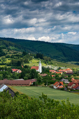 Fototapeta na wymiar Vertical image, small hungarian village with catholic church in Transylvania, Romania.