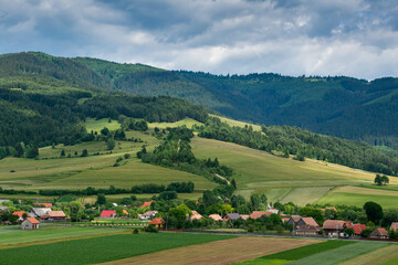 Fototapeta na wymiar Agricultural fields, small hungarian village at summertime in Transylvania, Romania.