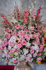Big bouquet of flowers in a vase on a gray wall background