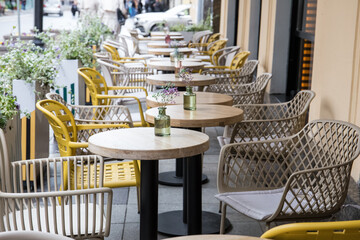 Empty restaurant tables are waiting for customers on the outdoor terrace.