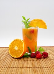 Non alcoholic cocktail with orange, raspberry and mint. Nice summer drink with fruit.