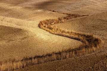 plowed fields in Italy in Tuscany. Autumn in October. The landscape is characterized by its...