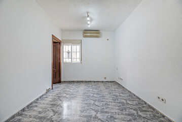 Empty living room with white and gray stoneware floors, wooden carpentry and air conditioning unit