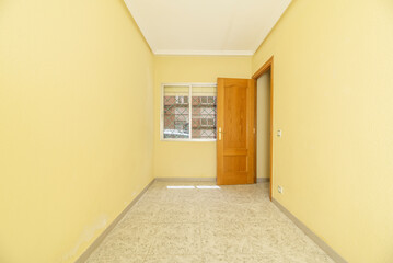 Empty room with tiled floor, pine woodwork and yellow painted walls