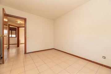 Empty living room with wooden floors, wooden doors with glass and plain white painted walls