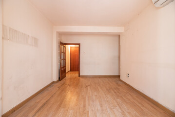 Empty living room with wooden floors, wooden doors with glass and plain white painted walls