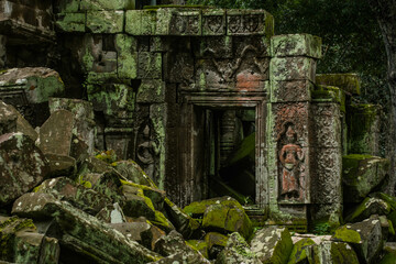 A sandstone carving of Nang Apsorn over the unrestored rock pile at Ta Prohm Temple, Angkor Wat,...