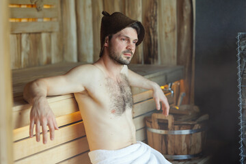 Serious man having a sauna bath in a steam room