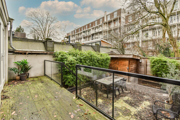 Neat paved patio with sitting area and small garden near wooden fence