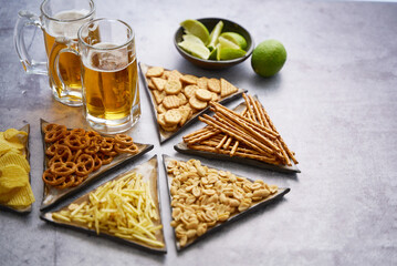 Tray with beer and snacks on table