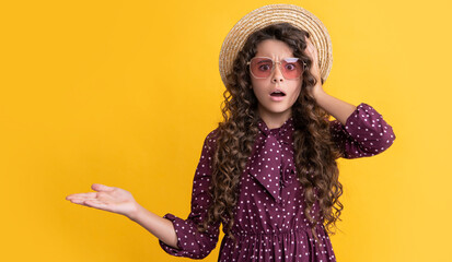 amazed child in straw hat and sunglasses with long brunette curly hair. copy space
