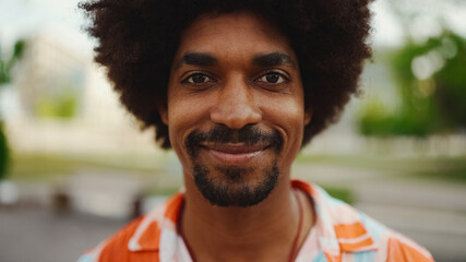 Close-up frontal portrait of young African American man wearing shirt looking at the camera and...
