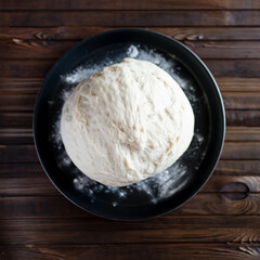 Fototapeta na wymiar Process of raising the dough in a special basket. Dough made from natural sourdough. Wheat dough. Fermentation. Top view. 
