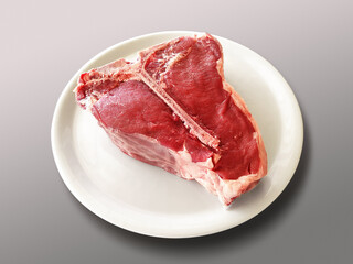 Round white plate with raw Fiorentina t-bone steak beef porterhouse