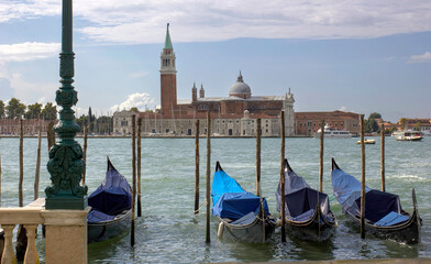 Venice, gondolas or gondole and San Giorgio Maggiore church landmark on background. Italy, Europe.