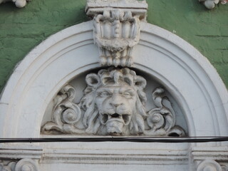 Stone lion head decorative element on the facade of the building