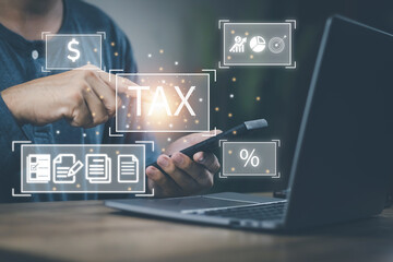 Financial tax return concept, a man's hand using a smartphone and a computer to work in accounting and tax