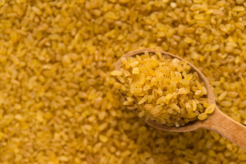 Bulgur - cooked and dried wheat groats, food background	