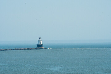 Harbor of Refuge lighthouse at the end of its breakwater at the mouth of the Delaware River as it heads out to he Atlantic - obrazy, fototapety, plakaty