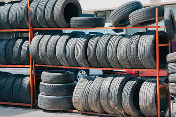 A lot of tires are stored on racks near the tire service shop.
