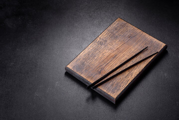 Wooden sushi sticks on a dark concrete background