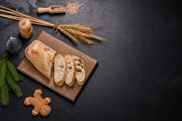 French baguette bread sliced on a wooden cutting board against a dark concrete background